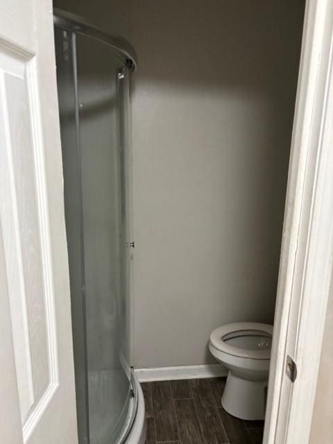 bathroom with toilet and a shower with door