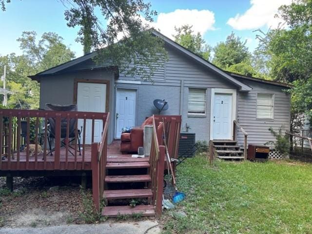 rear view of house with a lawn, cooling unit, and a wooden deck