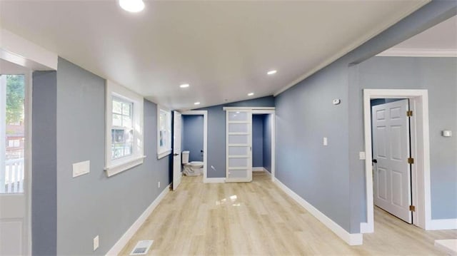 hallway with light hardwood / wood-style flooring and crown molding