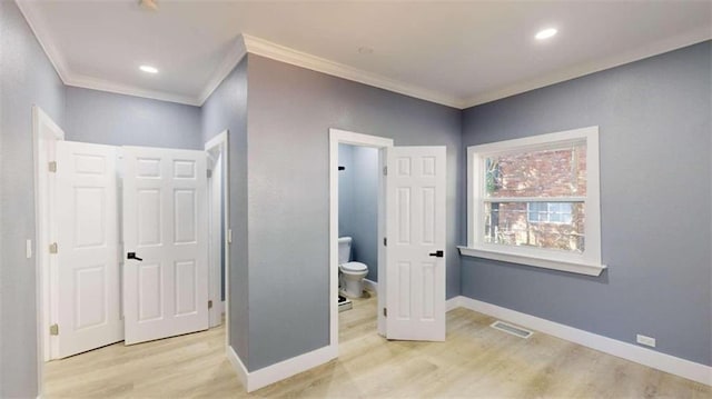 bedroom featuring connected bathroom, crown molding, and light wood-type flooring