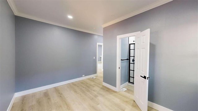 spare room featuring ornamental molding and light hardwood / wood-style flooring