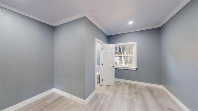 empty room with ornamental molding and light wood-type flooring