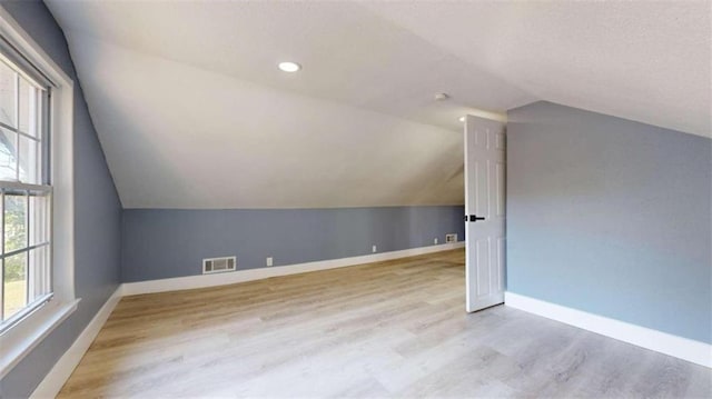 bonus room featuring vaulted ceiling and light hardwood / wood-style flooring