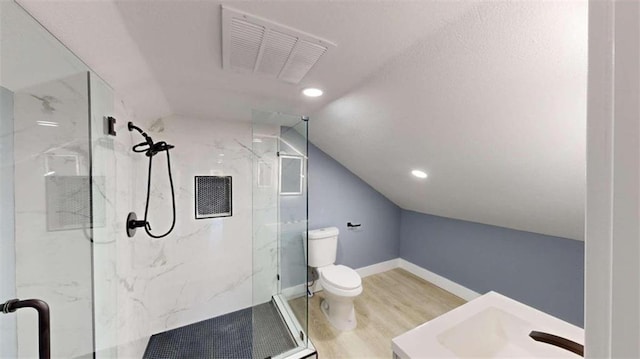 bathroom with hardwood / wood-style floors, vaulted ceiling, toilet, vanity, and an enclosed shower