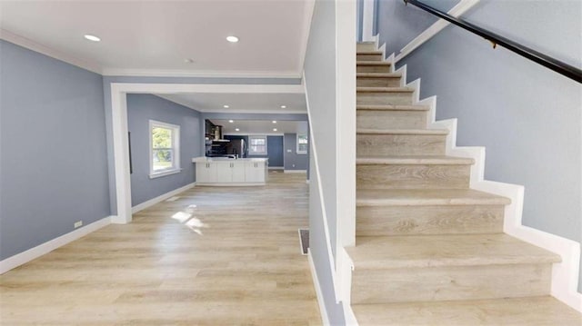 stairway featuring ornamental molding and hardwood / wood-style floors