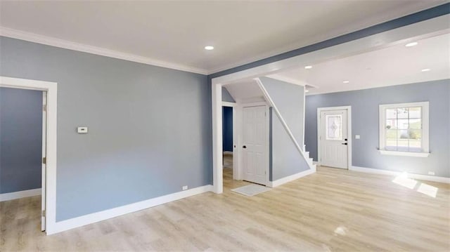 spare room with ornamental molding and light hardwood / wood-style floors