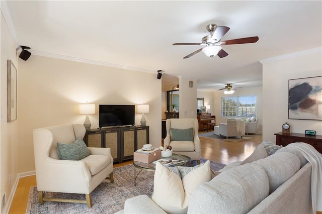 living room featuring light hardwood / wood-style flooring, crown molding, and ceiling fan