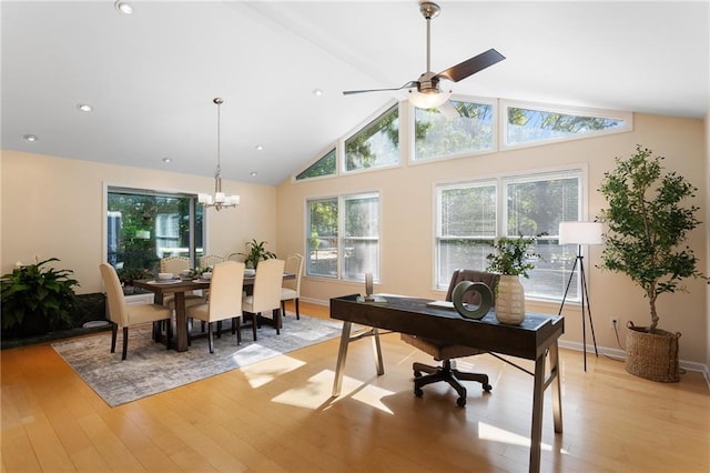 home office featuring ceiling fan with notable chandelier, high vaulted ceiling, and light wood-type flooring