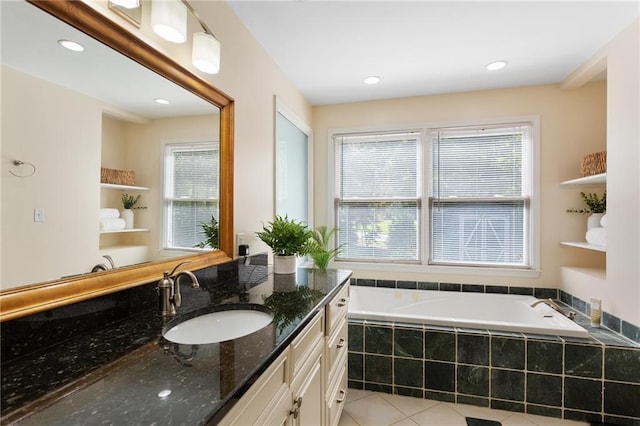 bathroom featuring vanity, tiled bath, a healthy amount of sunlight, and tile patterned flooring