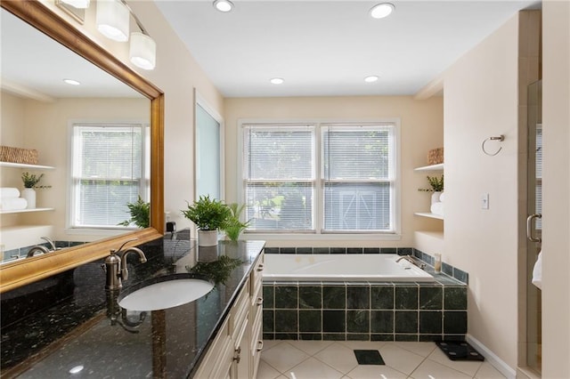 bathroom with vanity, tiled bath, a wealth of natural light, and tile patterned flooring