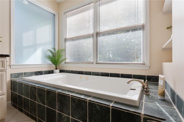 bathroom with a healthy amount of sunlight, tiled tub, and tile patterned floors