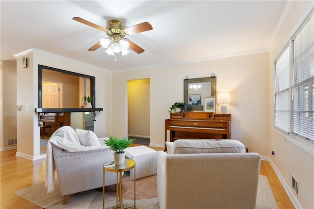 living room featuring light hardwood / wood-style floors, crown molding, and ceiling fan