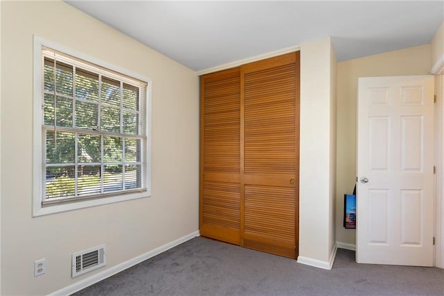 unfurnished bedroom with a closet and carpet flooring