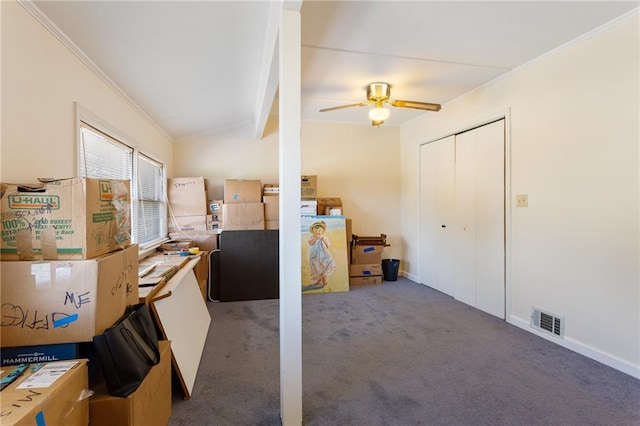 interior space with crown molding, dark colored carpet, and ceiling fan