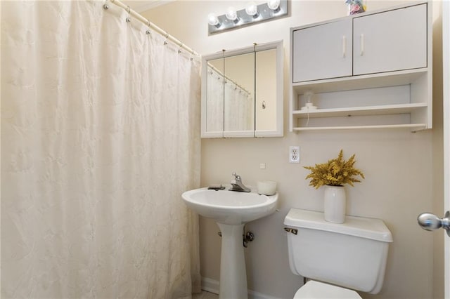 bathroom featuring toilet and curtained shower