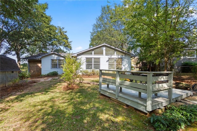 back of property with a wooden deck and a yard