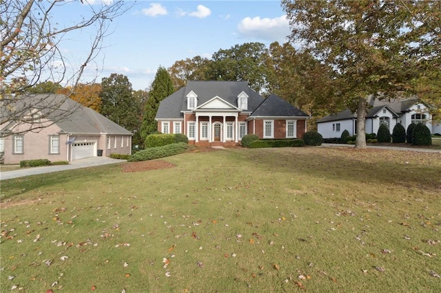 new england style home with covered porch, a garage, and a front yard