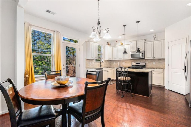 dining space featuring dark wood-style floors, visible vents, a notable chandelier, and recessed lighting