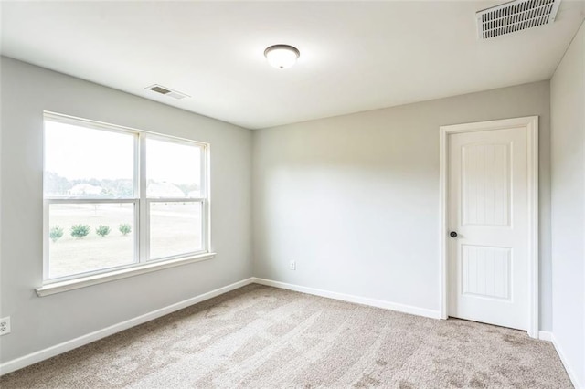 spare room featuring baseboards, visible vents, and carpet flooring