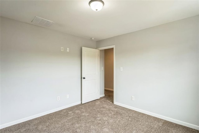 carpeted empty room with visible vents and baseboards