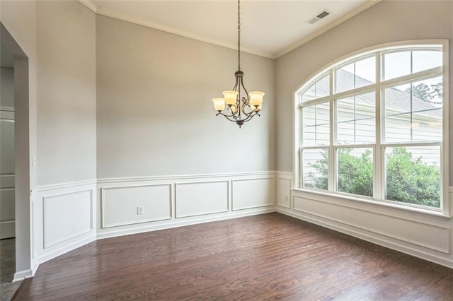 spare room featuring a chandelier, a wainscoted wall, visible vents, ornamental molding, and dark wood-style floors