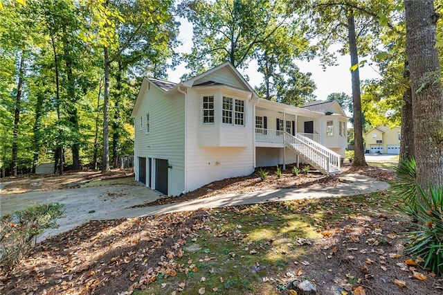 back of property with a garage and covered porch