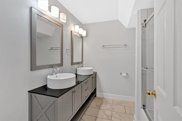 6851 Roswell Rd Unit J1, Atlanta, GA 30328 - bathroom featuring marble look tile flooring, double vanity, and baseboards
