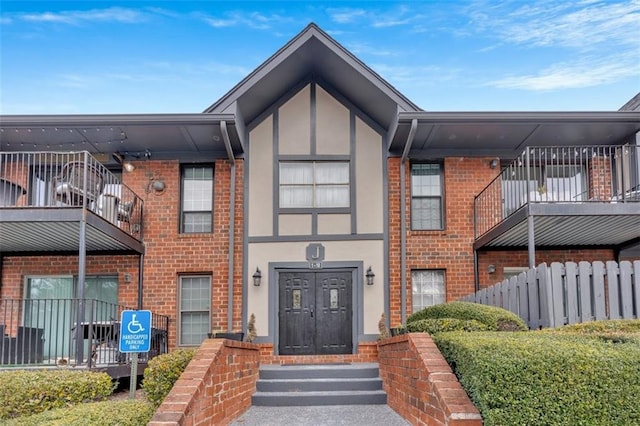 6851 Roswell Rd Unit J1, Atlanta, GA 30328 - view of front of house with brick siding, a balcony, and stucco siding