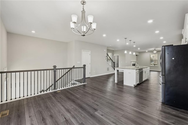 kitchen featuring white cabinetry, appliances with stainless steel finishes, a kitchen island with sink, and decorative light fixtures