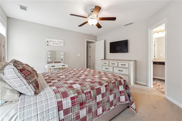 bedroom featuring ensuite bathroom, light carpet, and ceiling fan