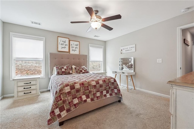 bedroom with multiple windows, light colored carpet, and ceiling fan