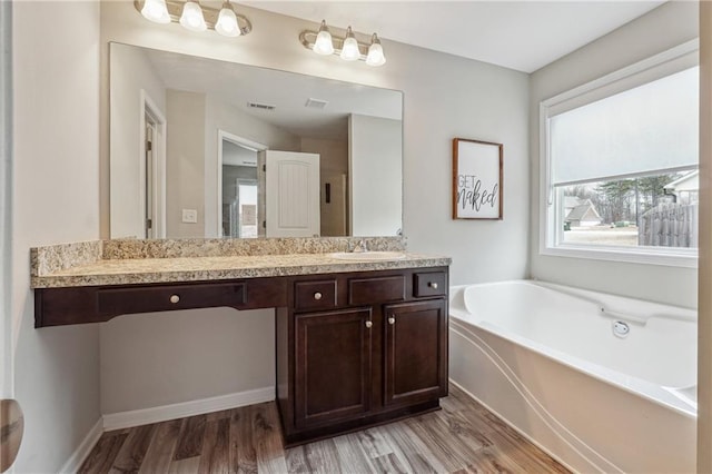 bathroom featuring vanity, a bathtub, and hardwood / wood-style flooring