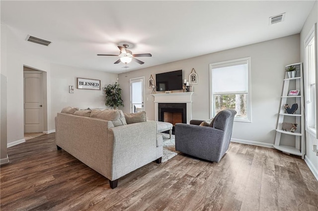 living room featuring ceiling fan and dark hardwood / wood-style flooring