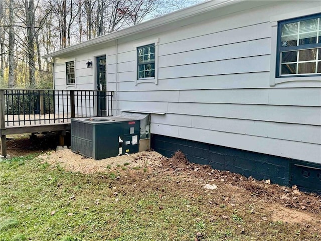 view of property exterior with cooling unit and a deck