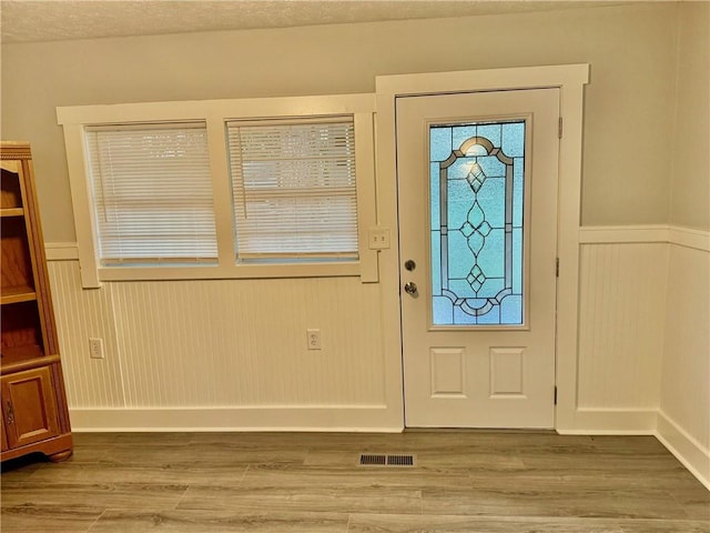 foyer entrance featuring hardwood / wood-style floors and a textured ceiling