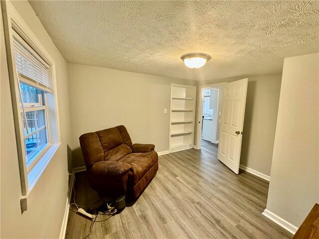 living area with hardwood / wood-style floors and a textured ceiling