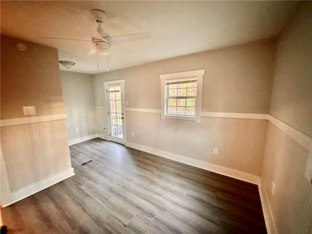 empty room with dark wood-type flooring and ceiling fan