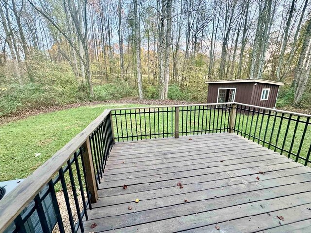 wooden deck with a lawn and an outdoor structure