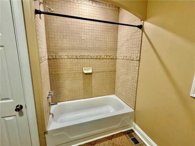 bathroom featuring tile patterned flooring and tiled shower / bath