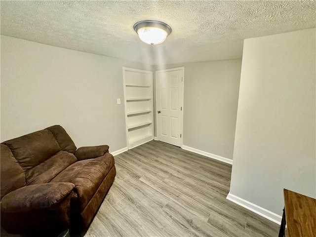 living area with hardwood / wood-style floors and a textured ceiling