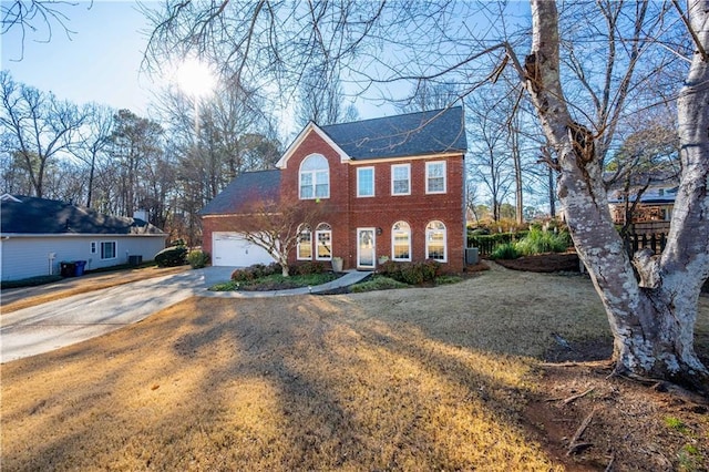 colonial inspired home with a front yard and a garage