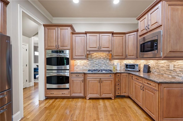 2260 Falkirk Pointe Dr, Marietta, GA 30062 - kitchen with appliances with stainless steel finishes, light wood-style flooring, stone countertops, decorative backsplash, and ornamental molding