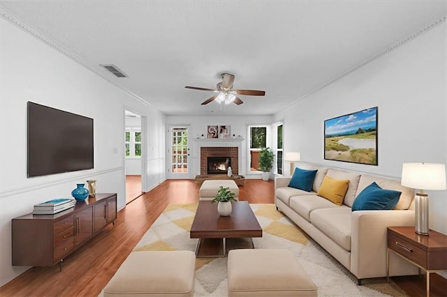1410 Kingfield Dr, Johns Creek, GA 30005 - living room featuring a ceiling fan, light wood-style flooring, a fireplace, and crown molding