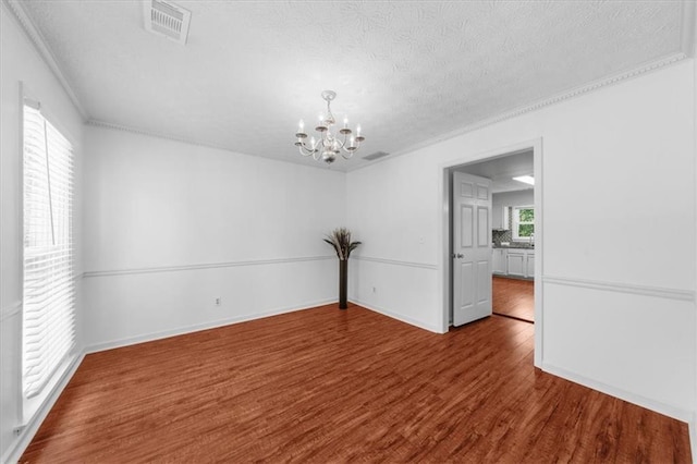 1410 Kingfield Dr, Johns Creek, GA 30005 - spare room featuring a chandelier, wood finished floors, a textured ceiling, and crown molding