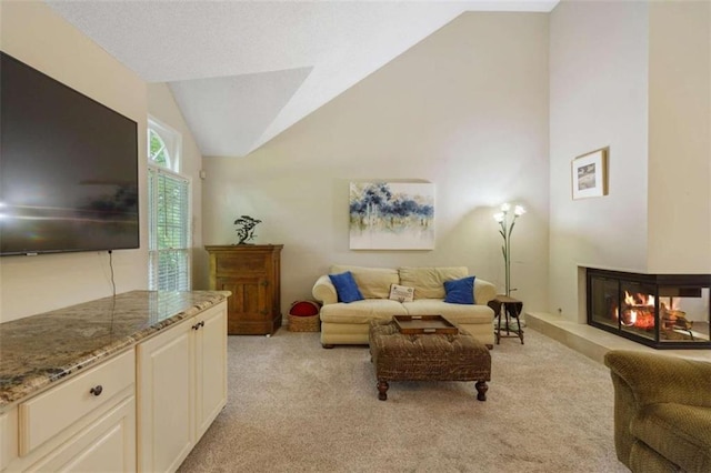 living room with light carpet, vaulted ceiling, and a multi sided fireplace