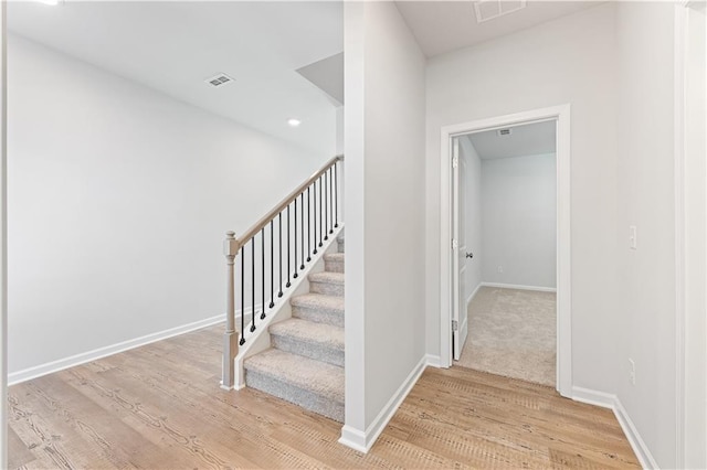 stairs with recessed lighting, wood finished floors, visible vents, and baseboards