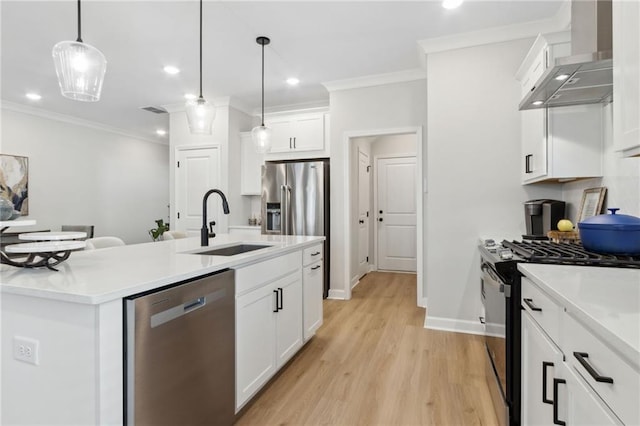 kitchen featuring wall chimney exhaust hood, a center island with sink, appliances with stainless steel finishes, and light countertops