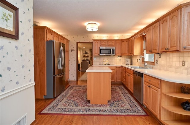 4366 Cedar Wood Dr SW, Lilburn, GA 30047 - kitchen featuring appliances with stainless steel finishes, a sink, wallpapered walls, wood finished floors, and light countertops