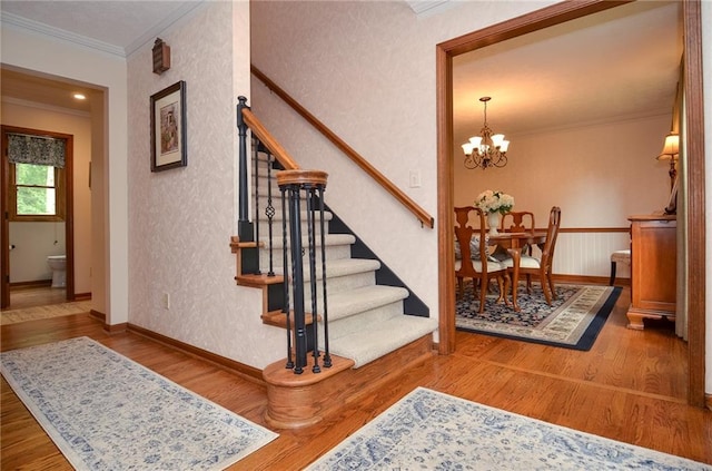 4366 Cedar Wood Dr SW, Lilburn, GA 30047 - stairway featuring ornamental molding, wood finished floors, a chandelier, and baseboards
