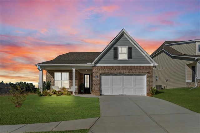 view of front of property featuring a yard, brick siding, and driveway